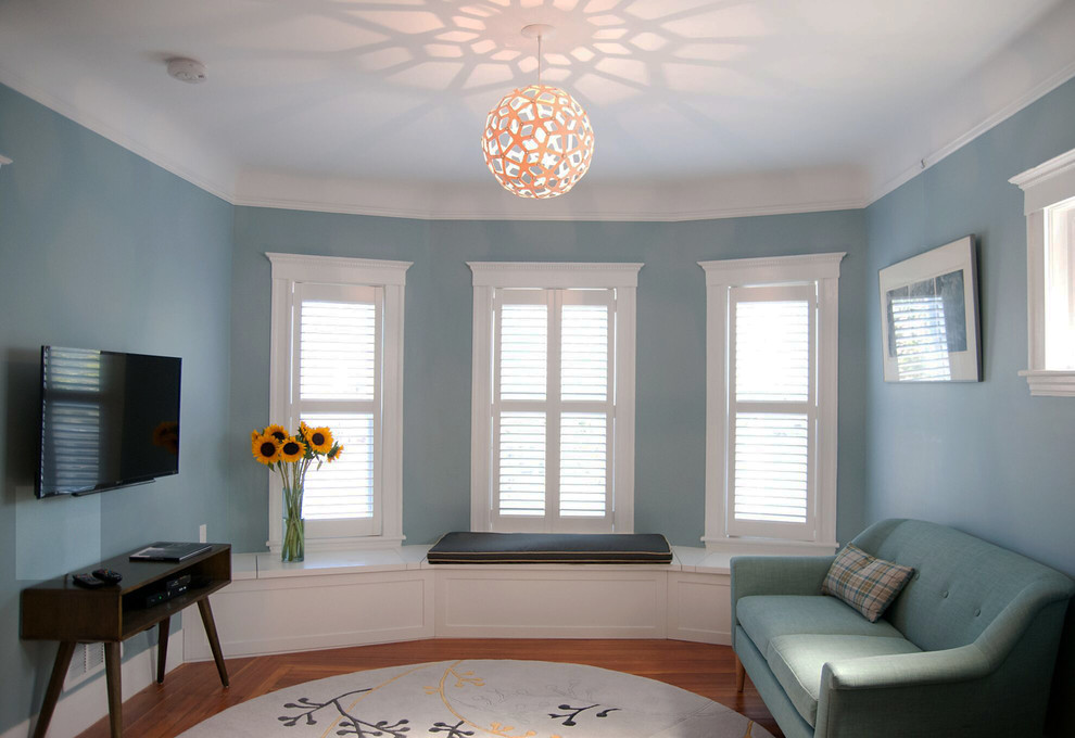 Foto de salón abierto retro de tamaño medio sin chimenea con paredes azules, suelo de madera en tonos medios y televisor colgado en la pared