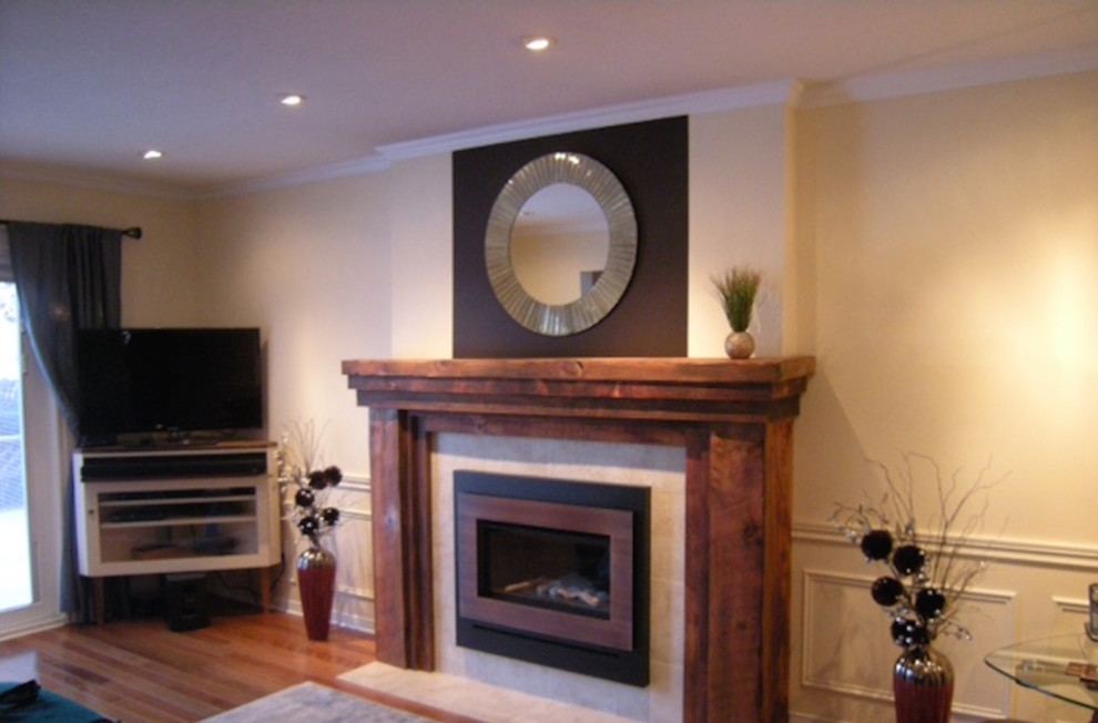 Photo of a medium sized classic formal enclosed living room in Toronto with medium hardwood flooring, a standard fireplace, a tiled fireplace surround, a wall mounted tv, beige walls and brown floors.