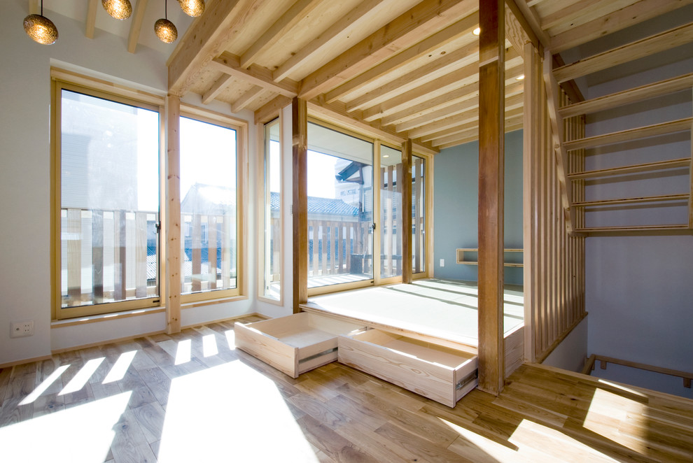 Idée de décoration pour un petit salon chalet ouvert avec un mur blanc, un sol de tatami, un téléviseur fixé au mur et un sol vert.