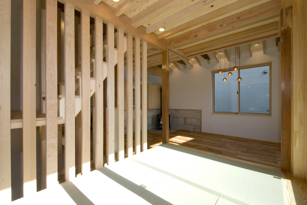 Kleines, Offenes Uriges Wohnzimmer mit weißer Wandfarbe, Tatami-Boden, Eckkamin, gefliester Kaminumrandung, TV-Wand und grünem Boden in Tokio