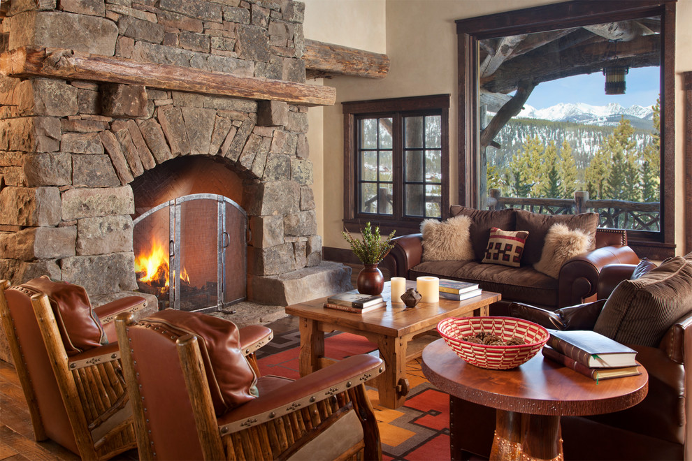 Пример оригинального дизайна: гостиная комната в классическом стиле с стандартным камином, фасадом камина из камня и коричневым диваном без телевизора