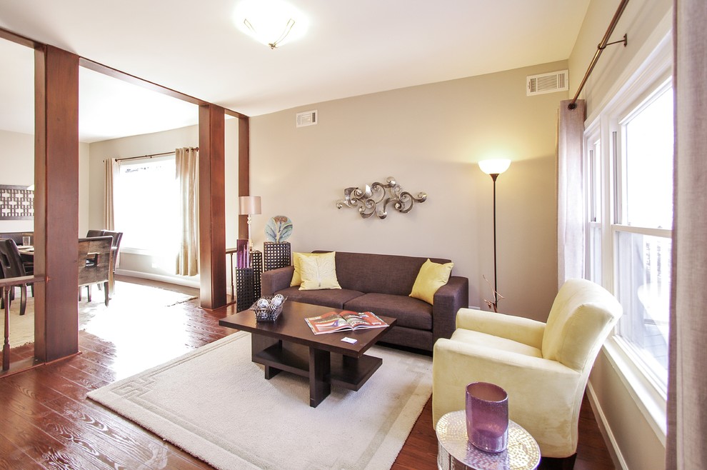 Imagen de salón abierto moderno de tamaño medio sin chimenea y televisor con paredes beige, suelo de madera en tonos medios y suelo marrón