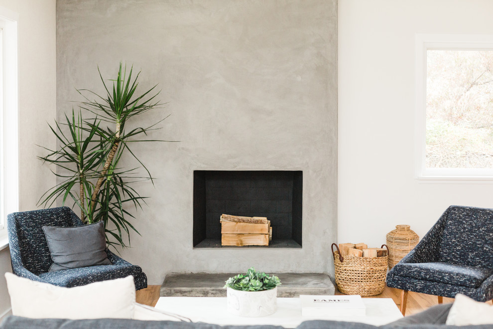 Photo of a rural living room in San Diego with a concrete fireplace surround.