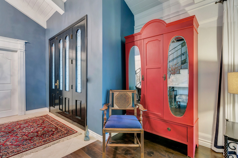 Großes, Repräsentatives, Offenes Klassisches Wohnzimmer ohne Kamin mit blauer Wandfarbe, braunem Holzboden und freistehendem TV in Los Angeles