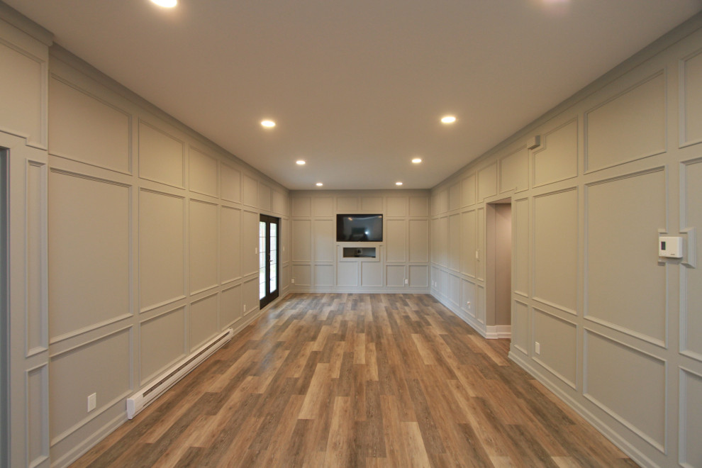 This is an example of a traditional grey and white living room in Other with vinyl flooring, grey walls, a built-in media unit, brown floors and wainscoting.