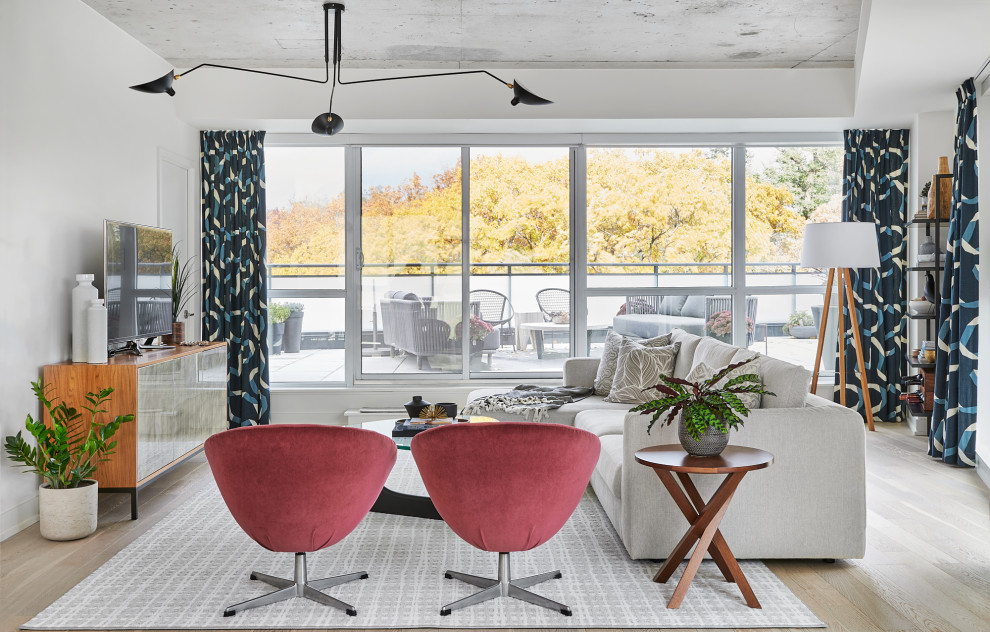 Foto di un soggiorno design di medie dimensioni e aperto con pareti bianche, parquet chiaro, TV autoportante e pavimento beige