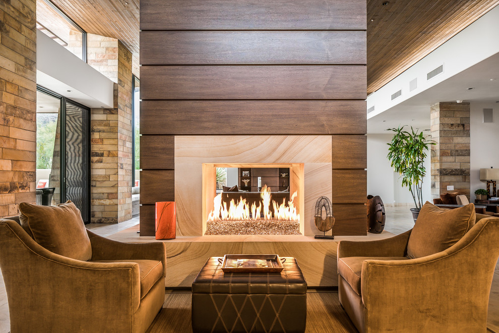 Inspiration pour un très grand salon design ouvert avec une cheminée double-face et un manteau de cheminée en bois.