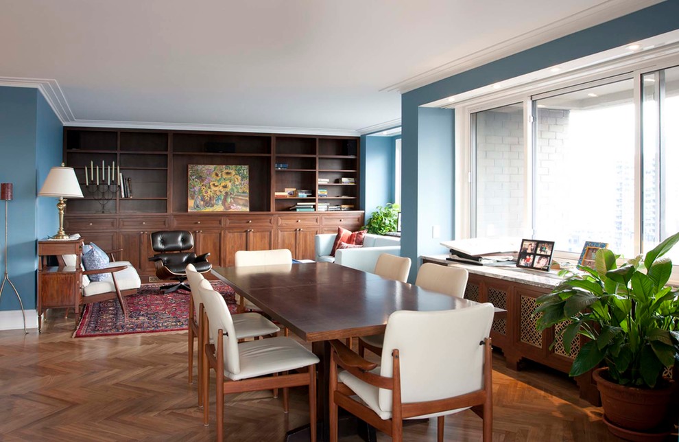 Источник вдохновения для домашнего уюта: открытая гостиная комната среднего размера в стиле ретро с синими стенами, паркетным полом среднего тона, коричневым полом, с книжными шкафами и полками и скрытым телевизором