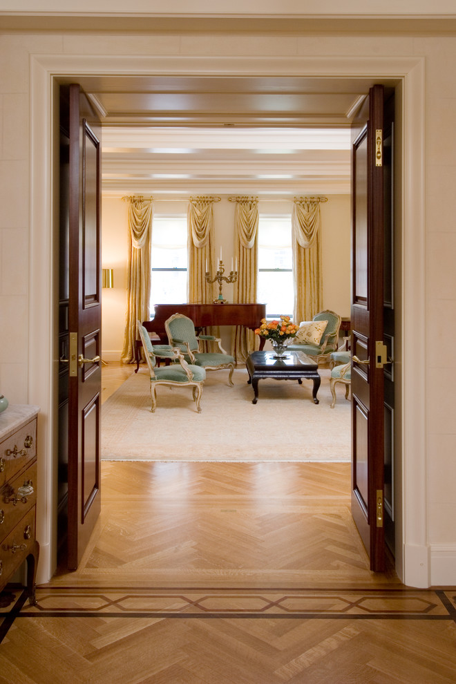 Large elegant enclosed medium tone wood floor living room photo in New York with beige walls