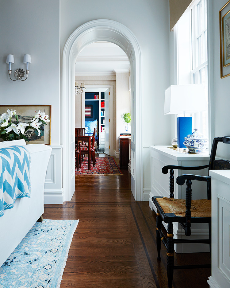 Immagine di un soggiorno chic aperto con sala formale, pareti beige, pavimento in legno massello medio e TV nascosta