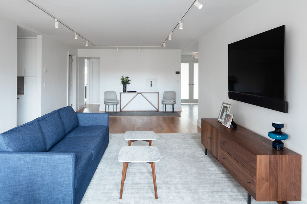 Пример оригинального дизайна: открытая гостиная комната среднего размера в современном стиле с белыми стенами, светлым паркетным полом и телевизором на стене