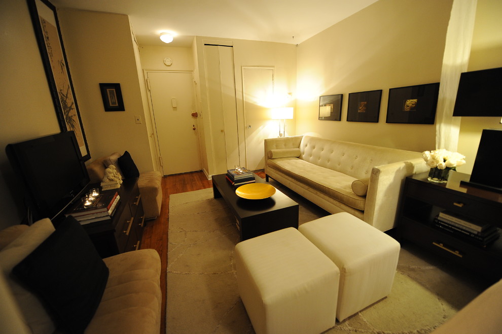 Immagine di un soggiorno design di medie dimensioni e aperto con sala formale, pareti beige, pavimento in legno massello medio, nessun camino, TV autoportante e pavimento marrone