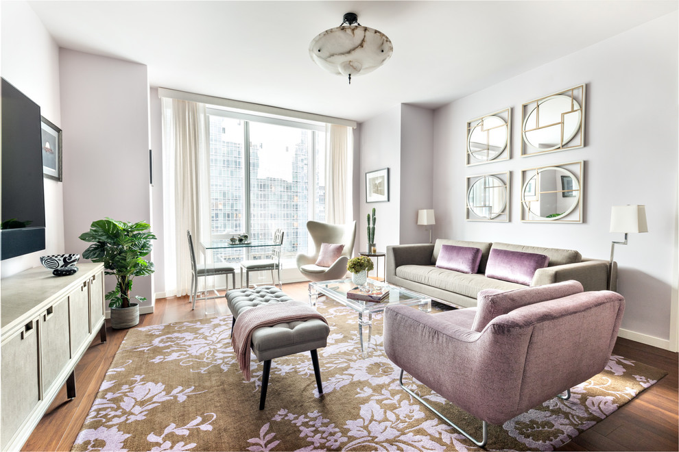 Inspiration pour un salon design de taille moyenne et ouvert avec un mur violet, parquet foncé, aucune cheminée, un téléviseur fixé au mur et un sol marron.