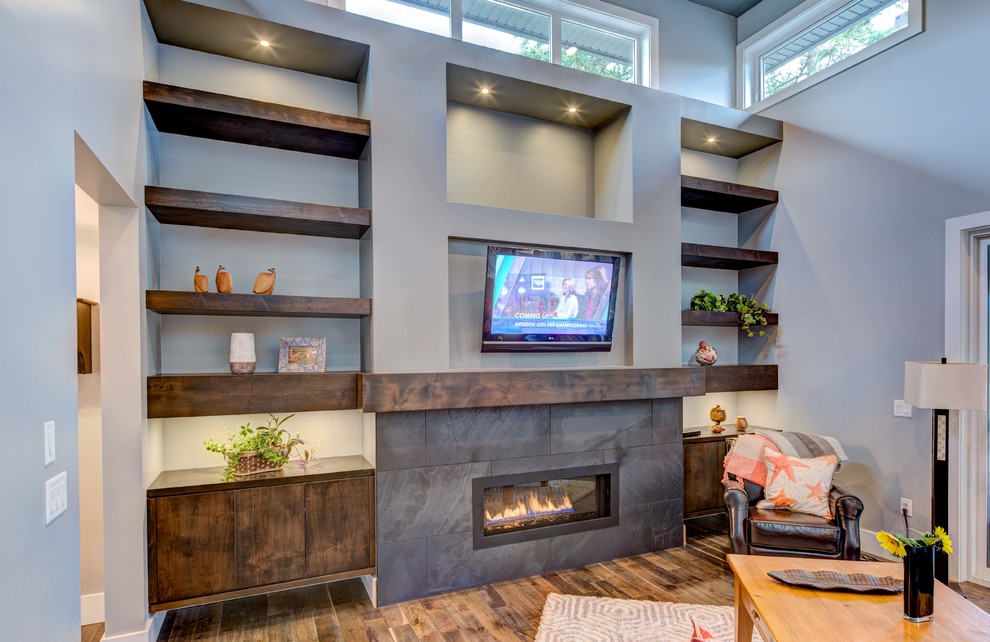 This is an example of a medium sized classic open plan living room in Vancouver with grey walls, medium hardwood flooring, a standard fireplace, a tiled fireplace surround and a wall mounted tv.