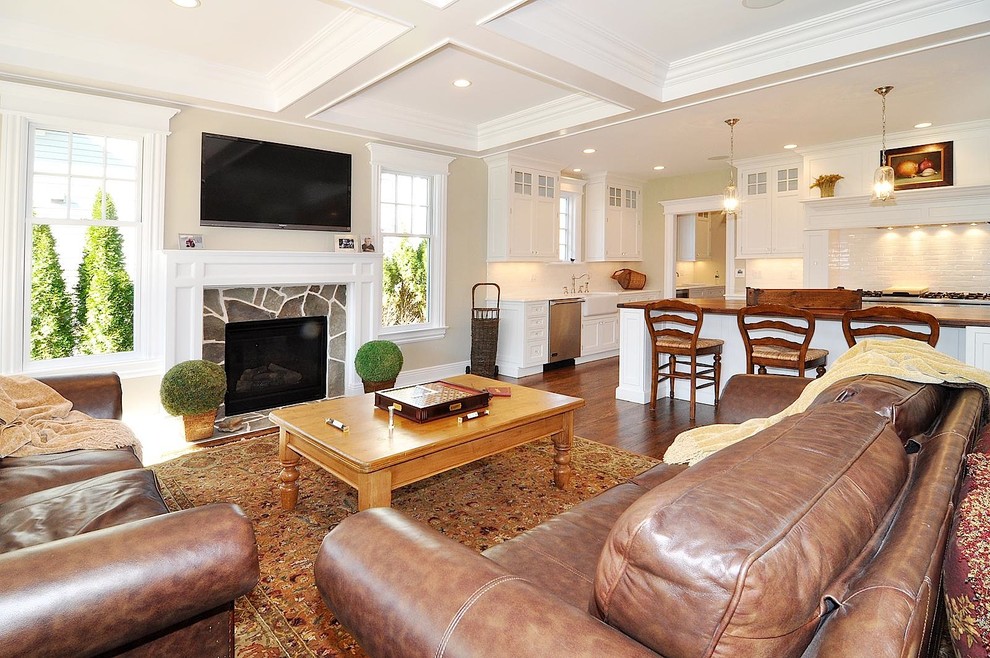 На фото: гостиная комната в классическом стиле с бежевыми стенами, стандартным камином и телевизором на стене с