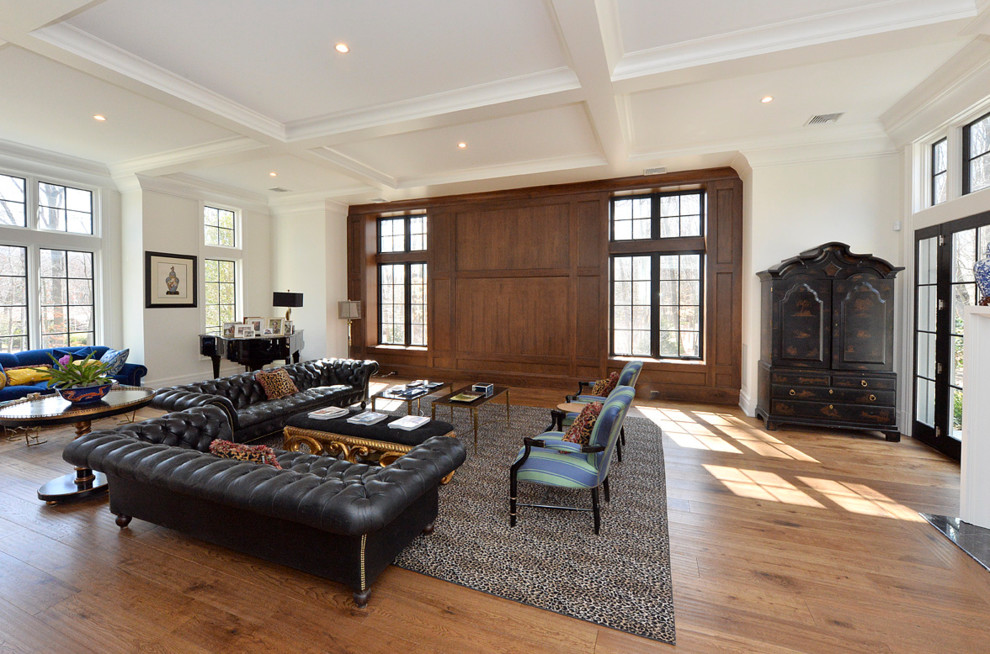 Foto de salón abierto tradicional renovado grande con paredes blancas, suelo de madera clara y televisor retractable