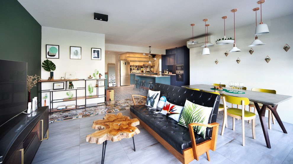 Imagen de salón abierto bohemio sin chimenea con paredes multicolor, televisor colgado en la pared y suelo gris