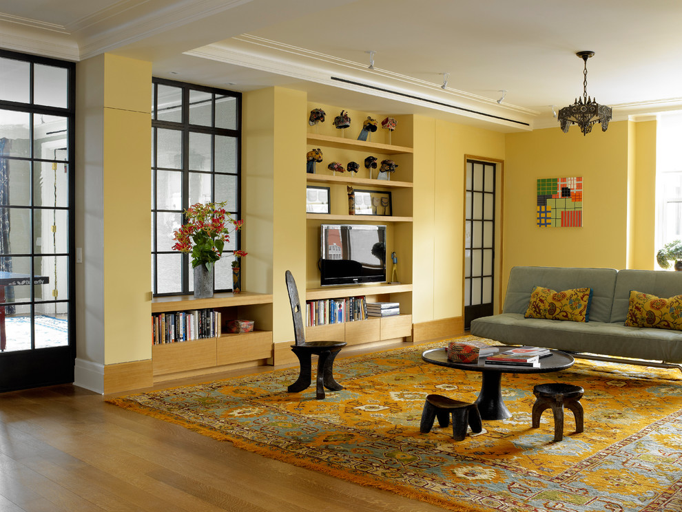 На фото: гостиная комната в современном стиле с желтыми стенами, отдельно стоящим телевизором и ковром на полу с