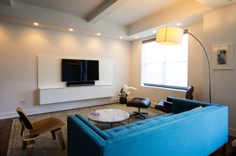 Ispirazione per un piccolo soggiorno design aperto con sala formale, pareti bianche, pavimento in legno massello medio e TV a parete