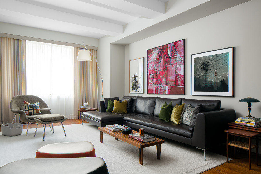 Imagen de salón abierto retro con paredes grises, suelo de madera en tonos medios y cortinas