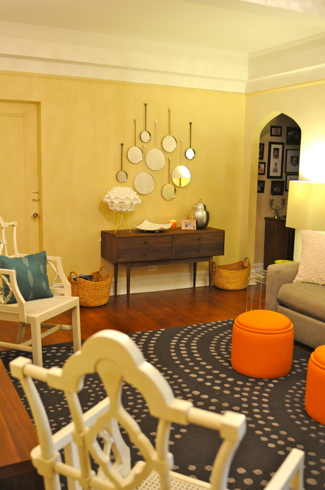 Foto de salón cerrado bohemio grande sin chimenea y televisor con paredes amarillas, suelo de madera en tonos medios y suelo marrón