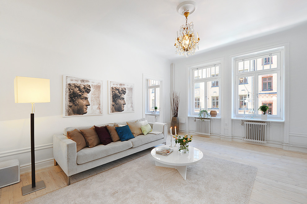 Photo of a large scandinavian formal enclosed living room in Stockholm with light hardwood flooring, white walls, no fireplace and no tv.