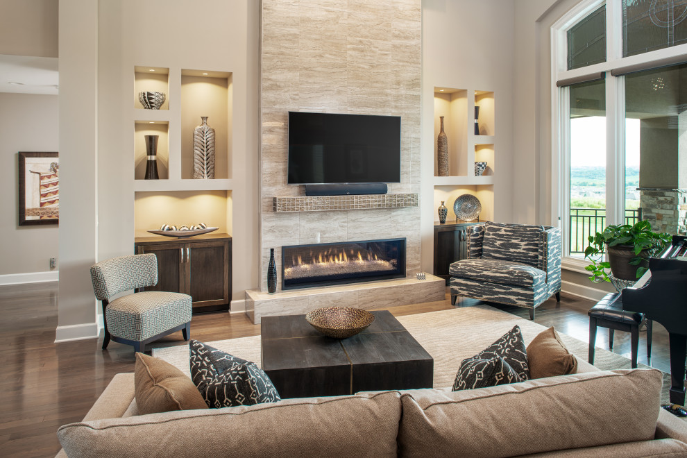 Photo of a large traditional formal open plan living room in Omaha with beige walls, dark hardwood flooring, a ribbon fireplace, a tiled fireplace surround, a wall mounted tv and brown floors.