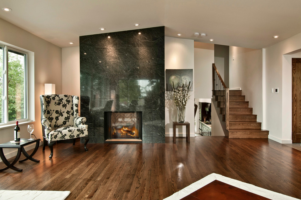 Aménagement d'un grand salon contemporain ouvert avec une salle de réception, un mur blanc, un sol en bois brun, une cheminée standard, un manteau de cheminée en pierre et aucun téléviseur.