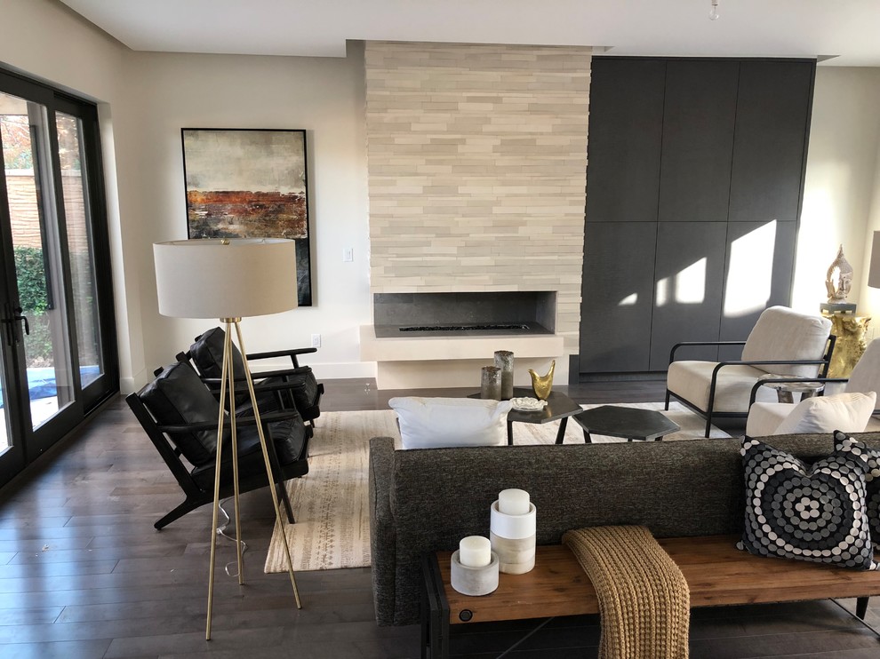 Стильный дизайн: открытая гостиная комната среднего размера в стиле модернизм с белыми стенами, темным паркетным полом, горизонтальным камином, фасадом камина из камня и коричневым полом - последний тренд