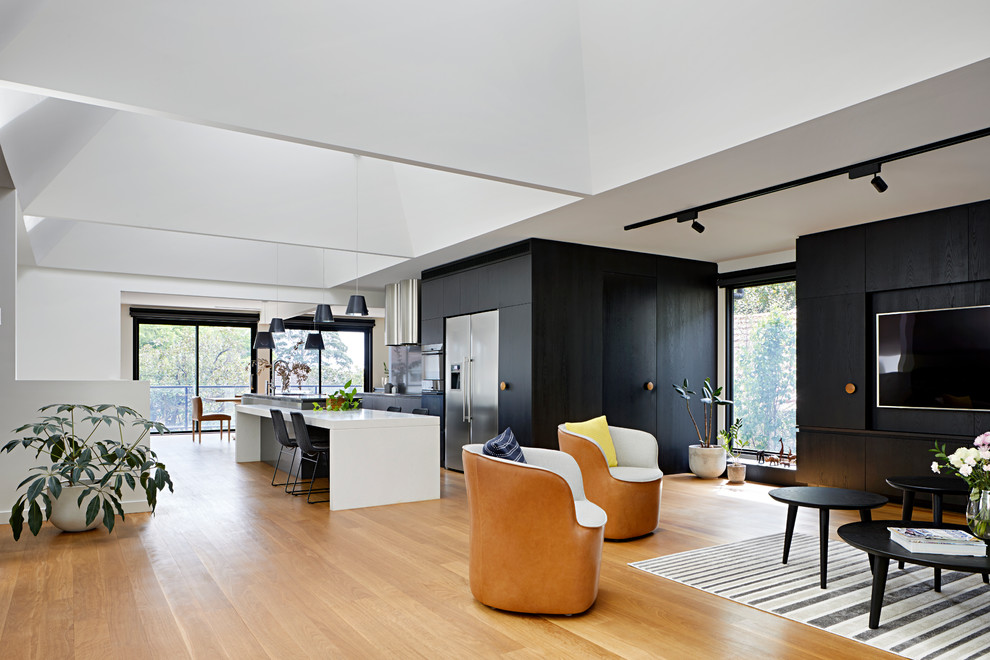 Design ideas for a medium sized contemporary open plan living room in Melbourne with black walls, medium hardwood flooring, a standard fireplace, a metal fireplace surround, a built-in media unit and brown floors.