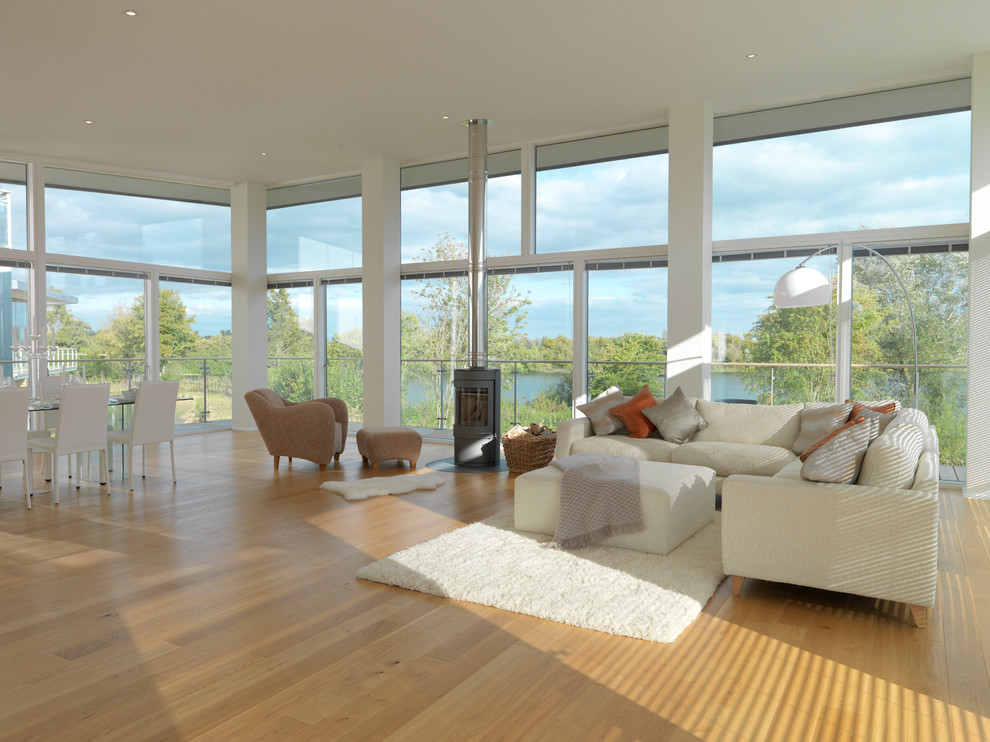 Idee per un soggiorno moderno con parquet chiaro e stufa a legna