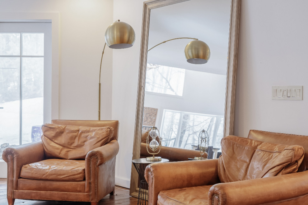 Foto di un soggiorno industriale con angolo bar, pareti bianche, pavimento in legno massello medio e pavimento marrone
