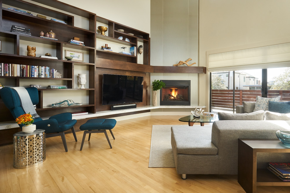 Foto de salón abierto moderno con paredes blancas, suelo de madera clara, chimenea de esquina, pared multimedia y madera
