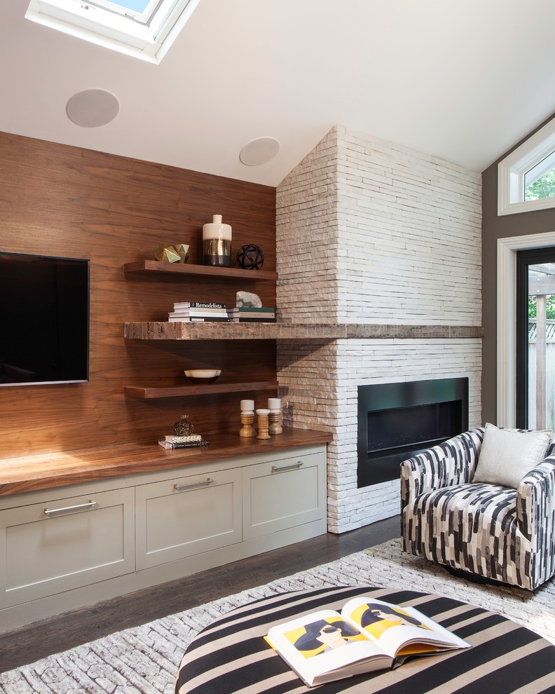 Klassisches Wohnzimmer mit bunten Wänden, dunklem Holzboden, Kaminumrandung aus Stein, TV-Wand und Gaskamin in New York