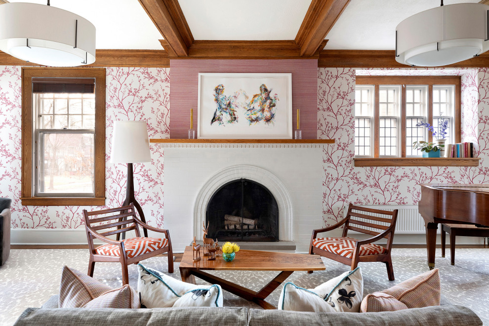 Стильный дизайн: гостиная комната в стиле неоклассика (современная классика) с розовыми стенами, паркетным полом среднего тона, стандартным камином, фасадом камина из кирпича, коричневым полом, балками на потолке и обоями на стенах - последний тренд