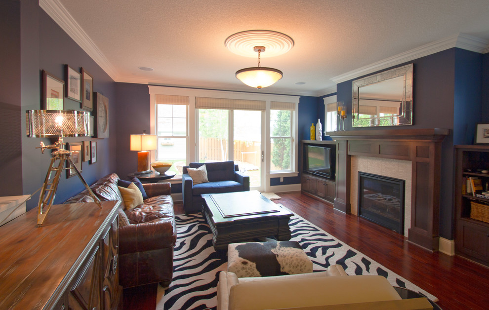 Пример оригинального дизайна: открытая гостиная комната среднего размера в современном стиле с синими стенами, паркетным полом среднего тона, стандартным камином, фасадом камина из дерева и отдельно стоящим телевизором