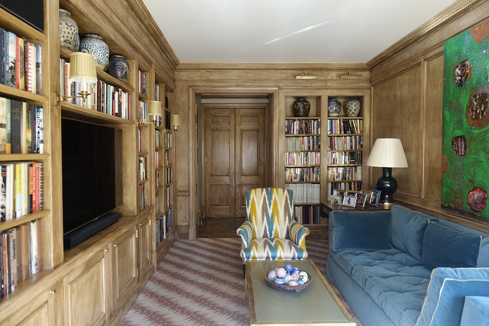 Imagen de biblioteca en casa cerrada tradicional con suelo de madera oscura y televisor colgado en la pared