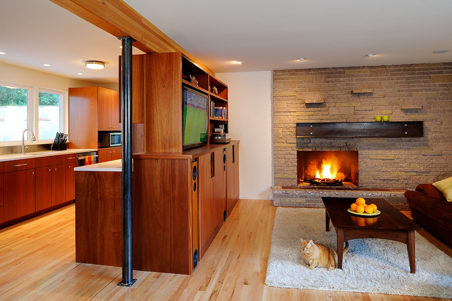 This is an example of a medium sized contemporary open plan living room in Seattle with a music area, beige walls, light hardwood flooring, a standard fireplace, a stone fireplace surround and a built-in media unit.