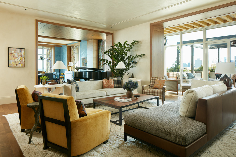 Immagine di un grande soggiorno chic aperto con sala della musica, pareti beige e pavimento in legno massello medio