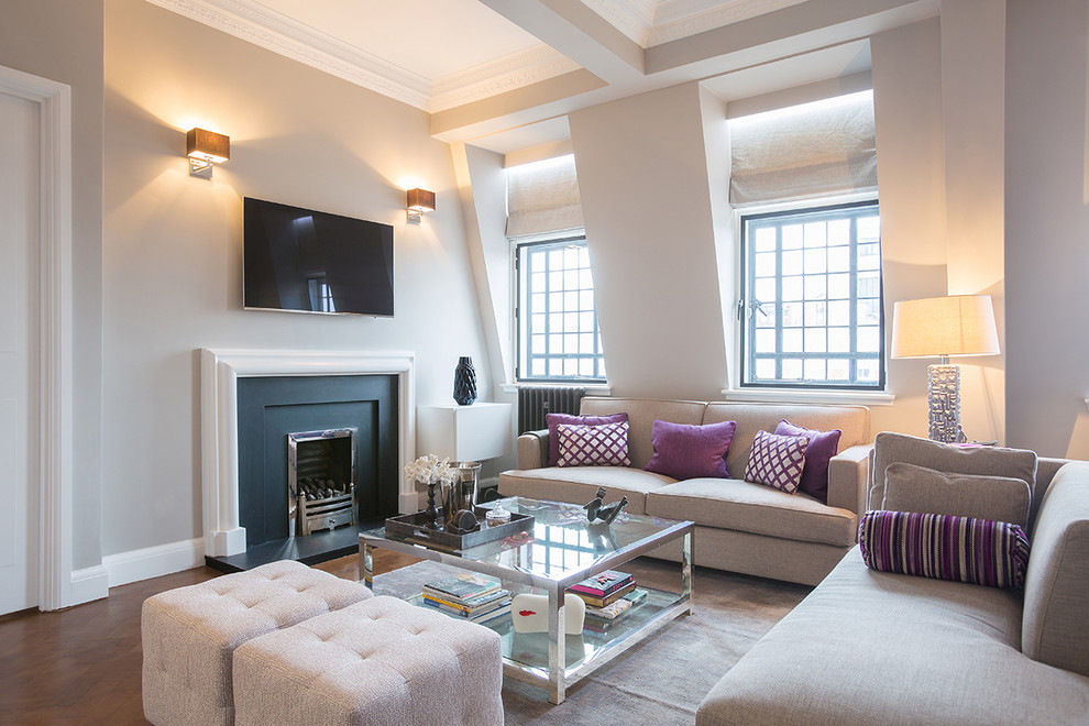 Mittelgroßes, Offenes Klassisches Wohnzimmer mit beiger Wandfarbe, braunem Holzboden, Kamin, Kaminumrandung aus Holz und TV-Wand in London