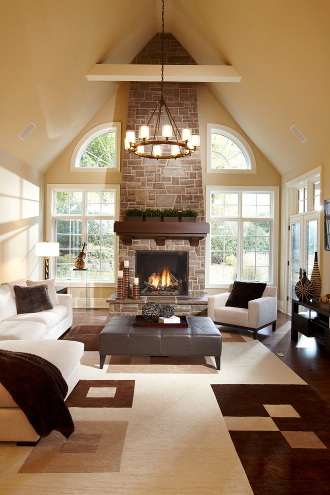 Inspiration pour un grand salon design ouvert avec un mur beige, une cheminée standard et un manteau de cheminée en pierre.