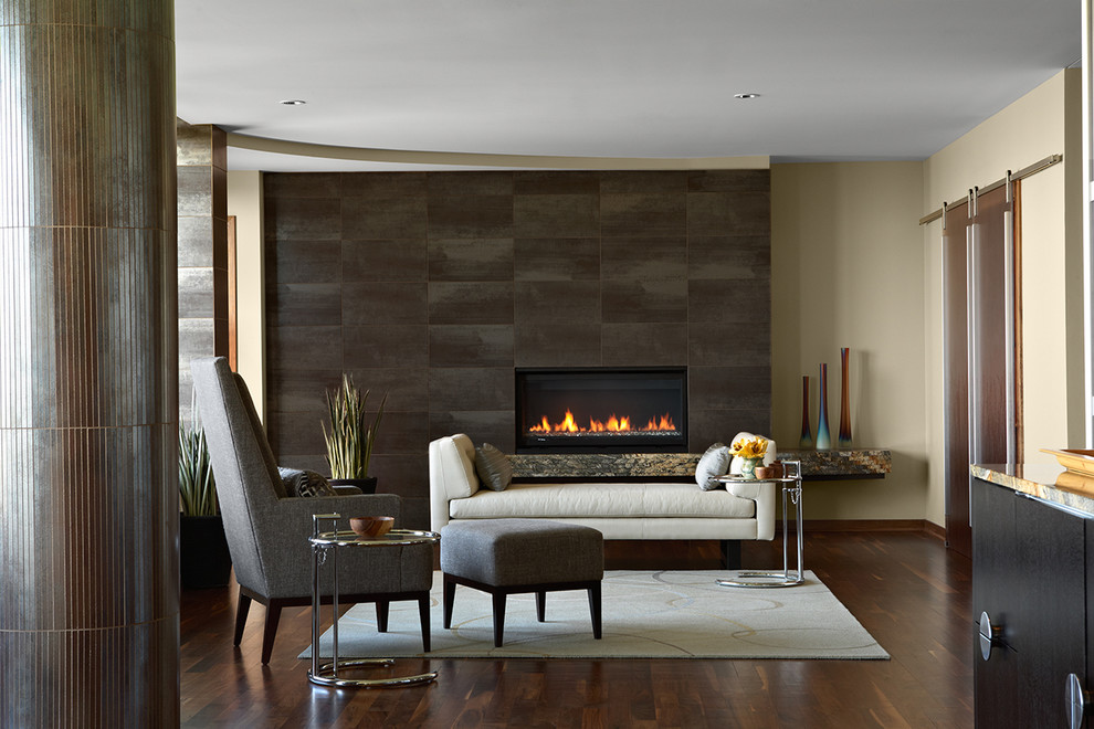 Offenes Modernes Wohnzimmer mit beiger Wandfarbe, dunklem Holzboden, Kamin und gefliester Kaminumrandung in Minneapolis