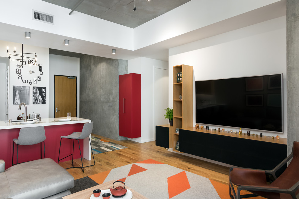 Imagen de salón tipo loft bohemio pequeño sin chimenea con paredes grises, suelo de madera clara y televisor colgado en la pared