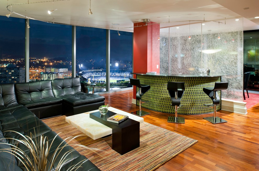 Diseño de salón con barra de bar abierto contemporáneo de tamaño medio con paredes rojas, suelo de madera en tonos medios y televisor colgado en la pared