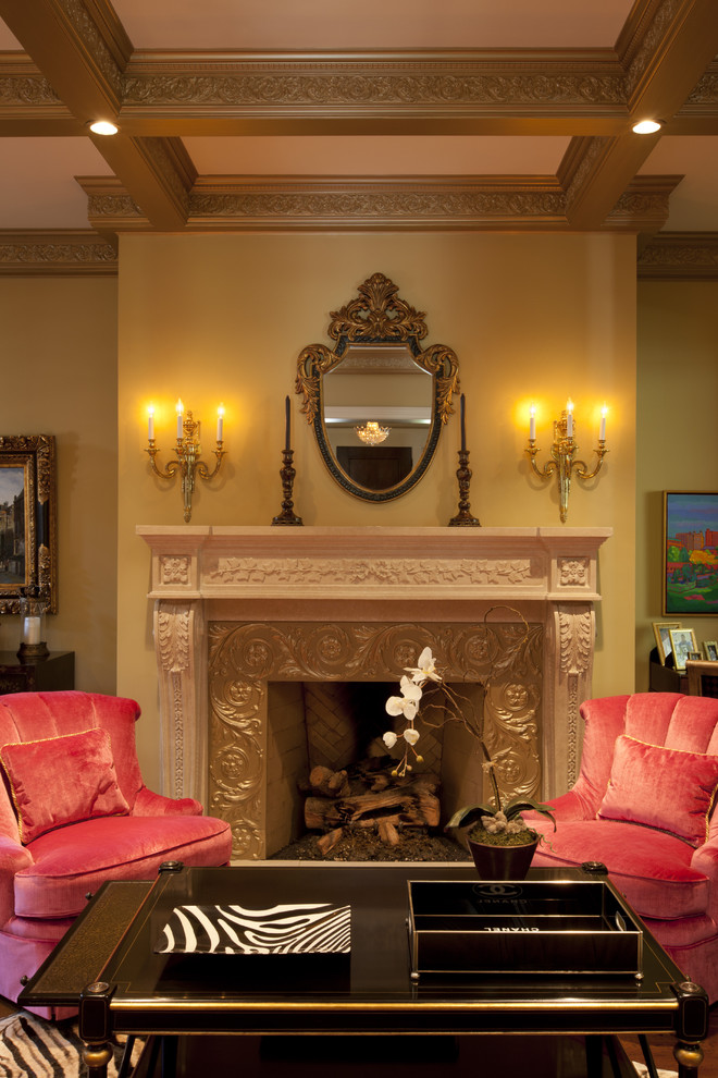 Esempio di un grande soggiorno chic con sala formale, pareti gialle, pavimento in legno verniciato, camino classico, cornice del camino in pietra e TV nascosta