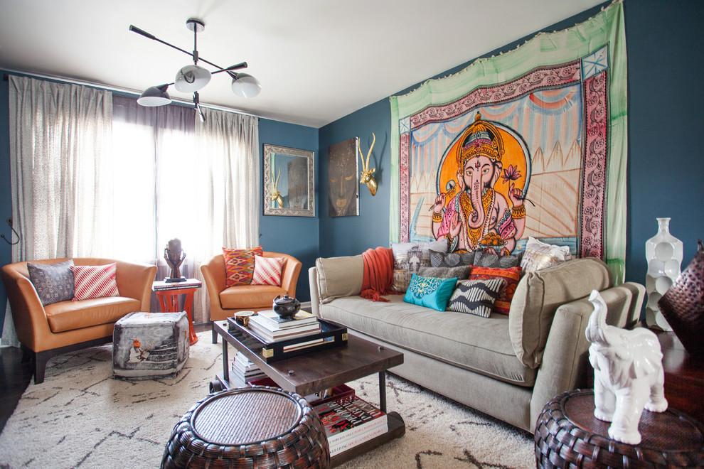 Imagen de salón abierto bohemio de tamaño medio sin chimenea con paredes azules, suelo de madera en tonos medios y televisor independiente