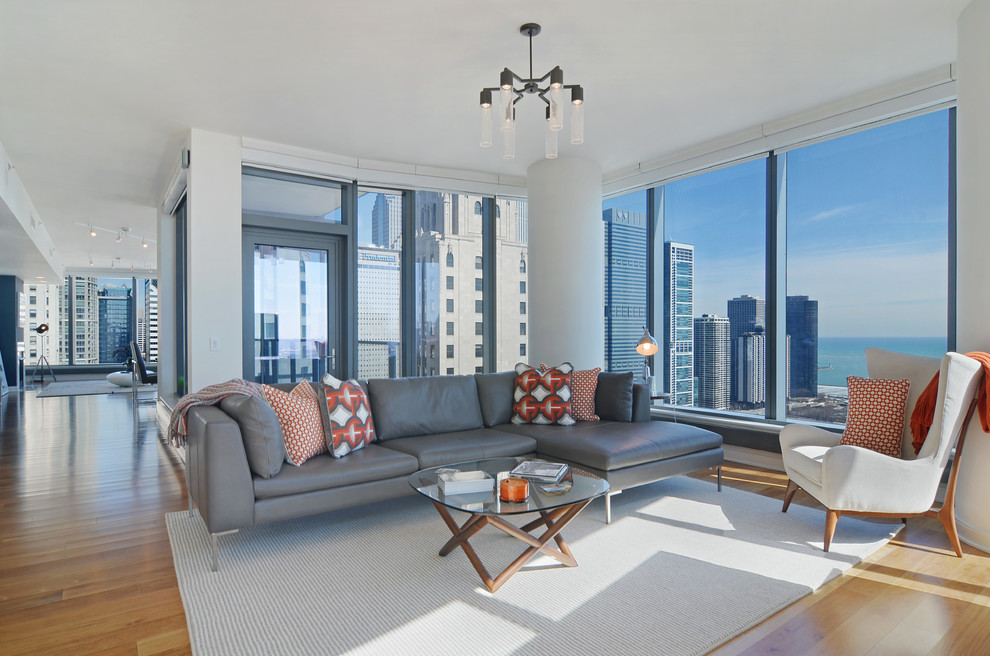 Offenes Modernes Wohnzimmer mit weißer Wandfarbe und braunem Holzboden in Chicago