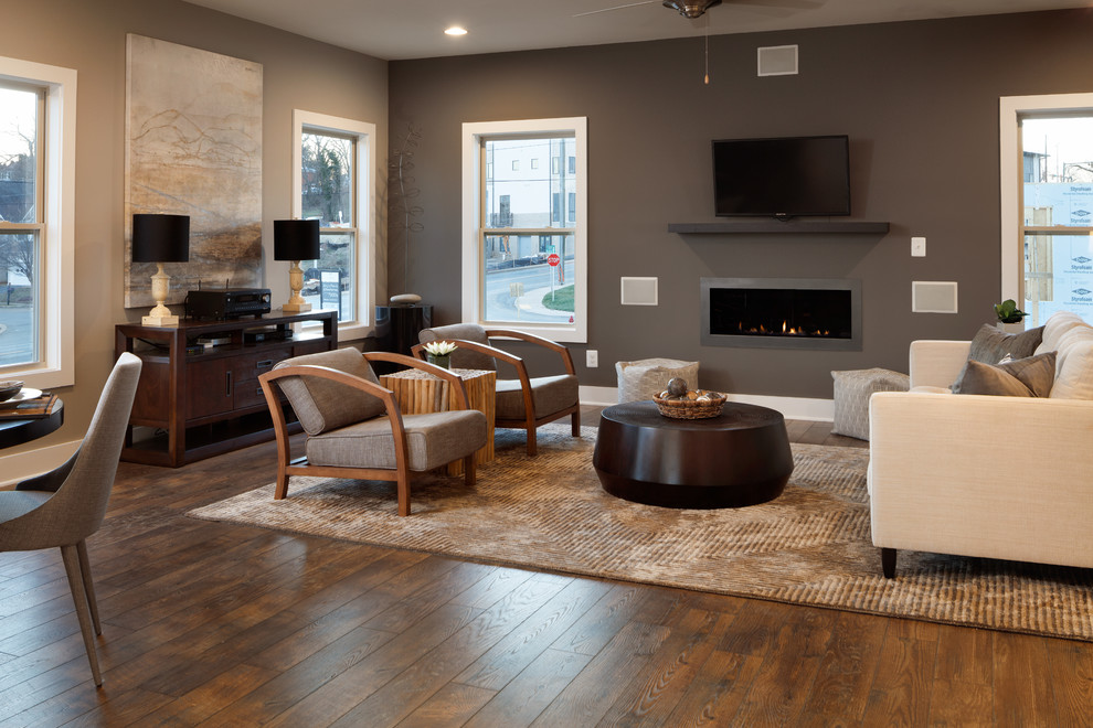 Offenes Modernes Wohnzimmer mit Laminat, Gaskamin, Kaminumrandung aus Metall, braunem Boden und grauer Wandfarbe in Sonstige