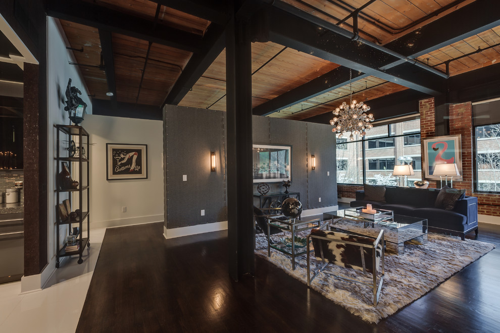 Photo of a large industrial open plan living room in Charlotte with black walls, painted wood flooring, no fireplace, a wall mounted tv and black floors.