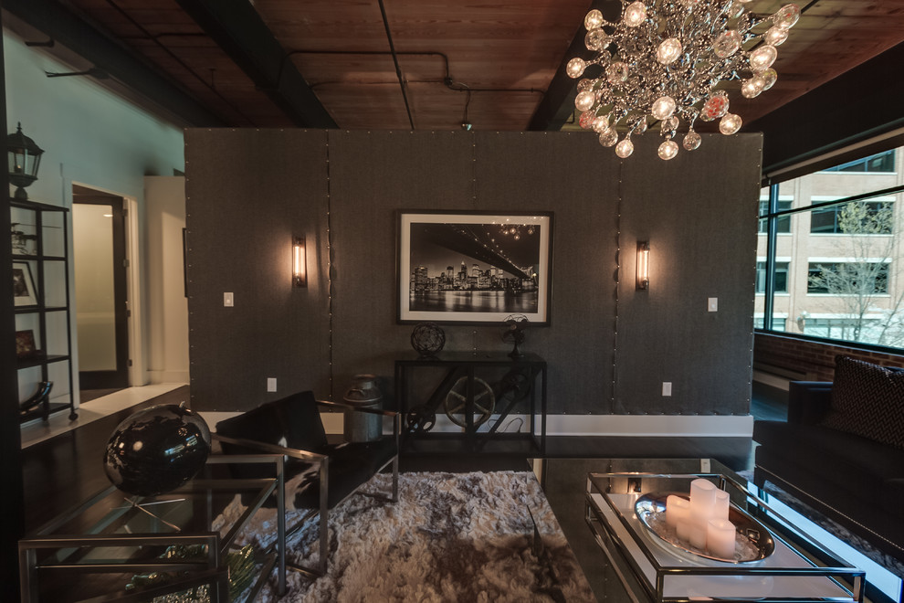 Großes, Offenes Industrial Wohnzimmer ohne Kamin mit schwarzer Wandfarbe, gebeiztem Holzboden, TV-Wand und schwarzem Boden in Charlotte